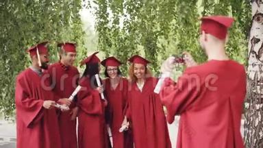 一名即将毕业的学生正在录下一段视频，他的朋友们穿着礼服，手里拿着<strong>毕业证</strong>书，挥手，摆姿势看着